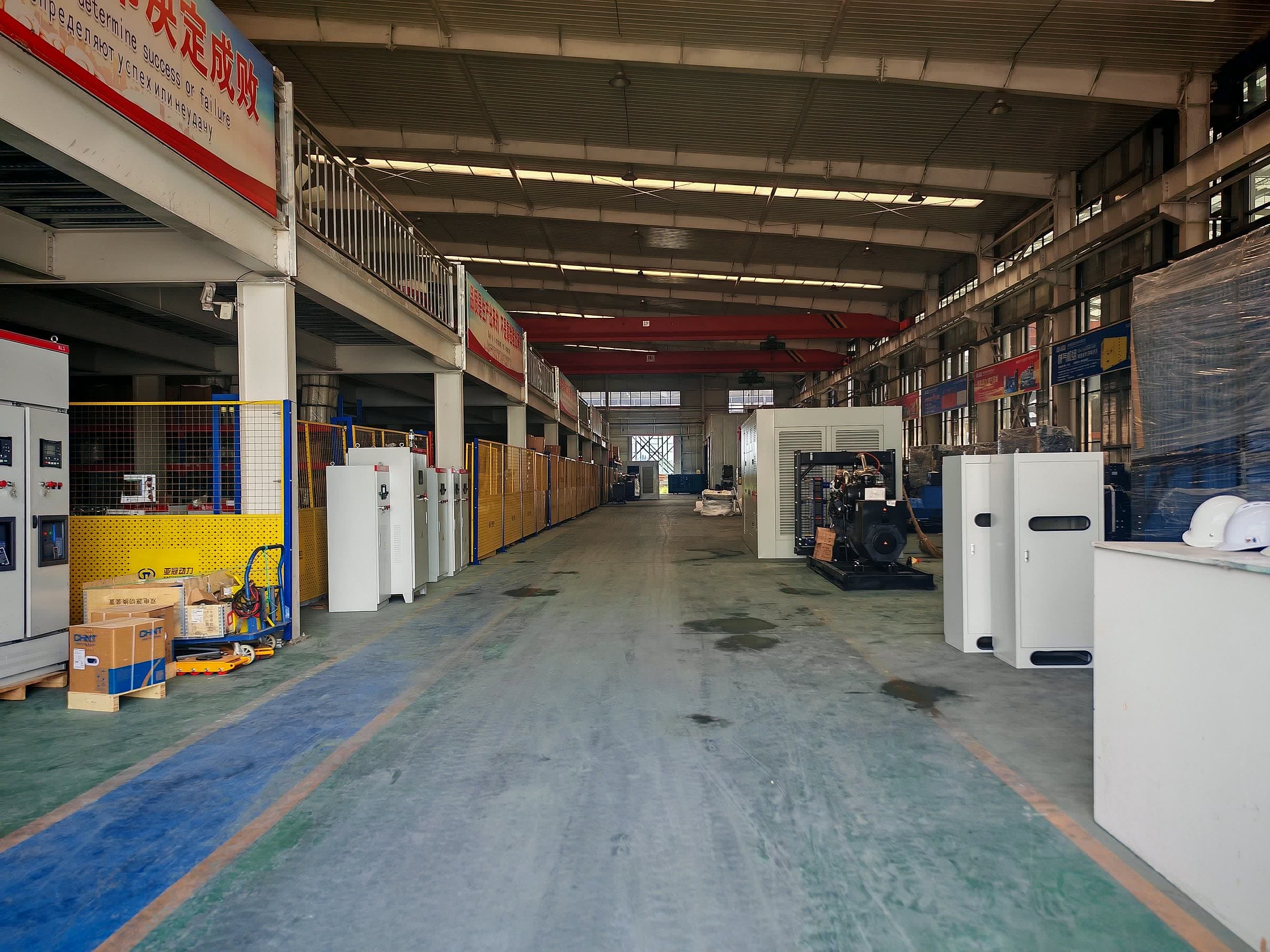 The parts store: generator sets and control cabinets on the racks, spare units wrapped and staged along the aisle